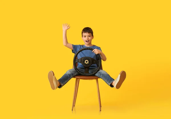 Niño Pequeño Con Volante Sentado Silla Sobre Fondo Color —  Fotos de Stock