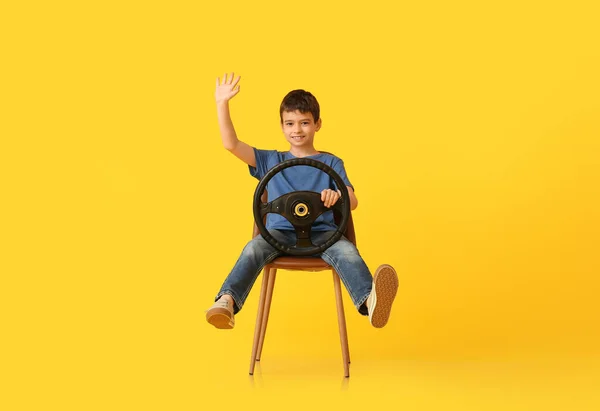 Niño Pequeño Con Volante Sentado Silla Sobre Fondo Color —  Fotos de Stock