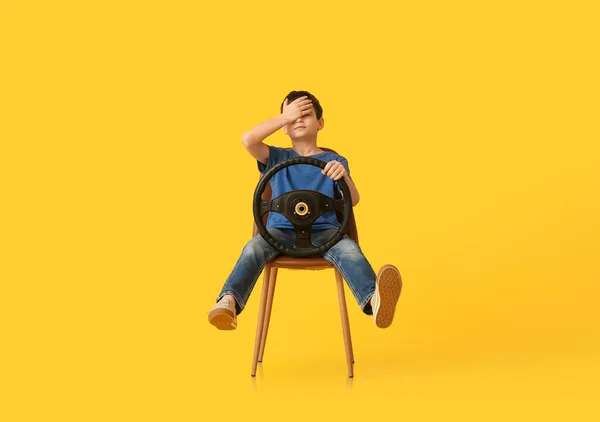 Petit Garçon Avec Volant Assis Dans Chaise Sur Fond Couleur — Photo