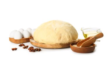 Taze hamurlu ahşap tahta, kuru maya ve beyaz arka planda malzemeler.