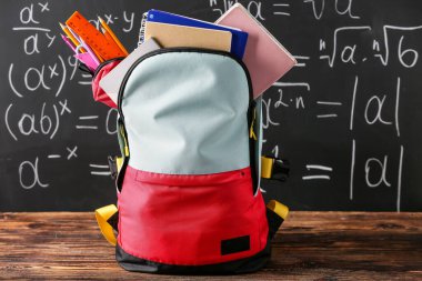 Tahtaya yapıştırılmış kırtasiyeli okul çantası.