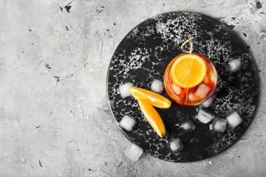 Gri arka planda bir bardak Aperol Spretz kokteyli.