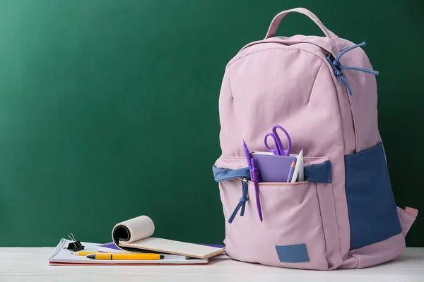 时尚的学校背包 桌上有文具和黑板做衬垫 — 图库照片
