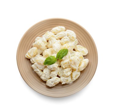 Beyaz arka planda krem soslu lezzetli gnocchi tabağı.