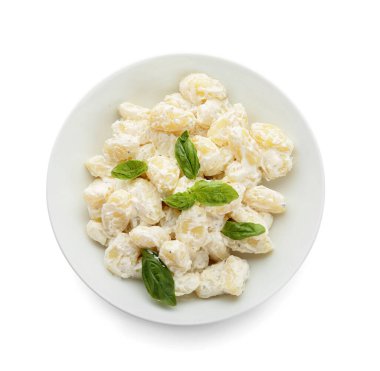 Beyaz arka planda kremalı bir kase lezzetli gnocchi.