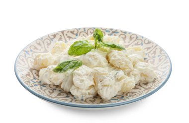 Beyaz arka planda krem soslu lezzetli gnocchi tabağı.