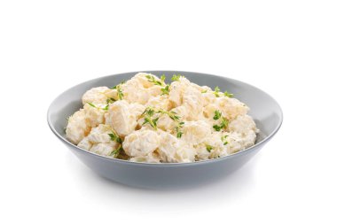 Beyaz arka planda kremalı bir kase lezzetli gnocchi.