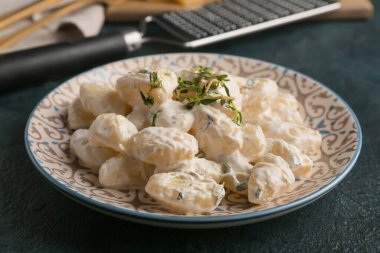 Siyah arka planda kremalı lezzetli gnocchi tabağı, yakın plan.