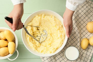 Ahşap arka planda lezzetli patates püresi hazırlayan kadın, yakın plan.