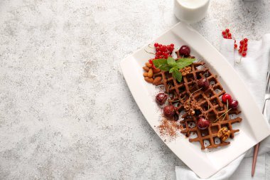 Bir tabak leziz çikolatalı Belçika Waffle 'ı ve hafif arka planda fındık.