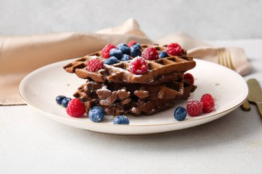 Bir tabak lezzetli çikolatalı Belçika Waffle 'ı ve masada böğürtlen.