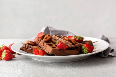 Masada çilekli ve bademli lezzetli çikolatalı Belçika Waffle tabağı.
