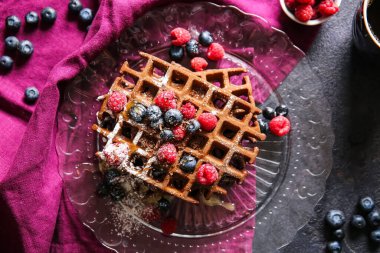 Bir tabak leziz çikolatalı Belçika Waffle 'ı. Siyah arka planda böğürtlen.