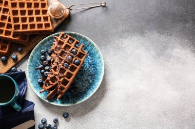 Siyah beyaz arka planda yaban mersinli lezzetli çikolatalı Belçika Waffle tabağı.