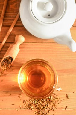 Ahşap zemin üzerinde bir fincan lezzetli hojicha yeşil çay ile kompozisyon