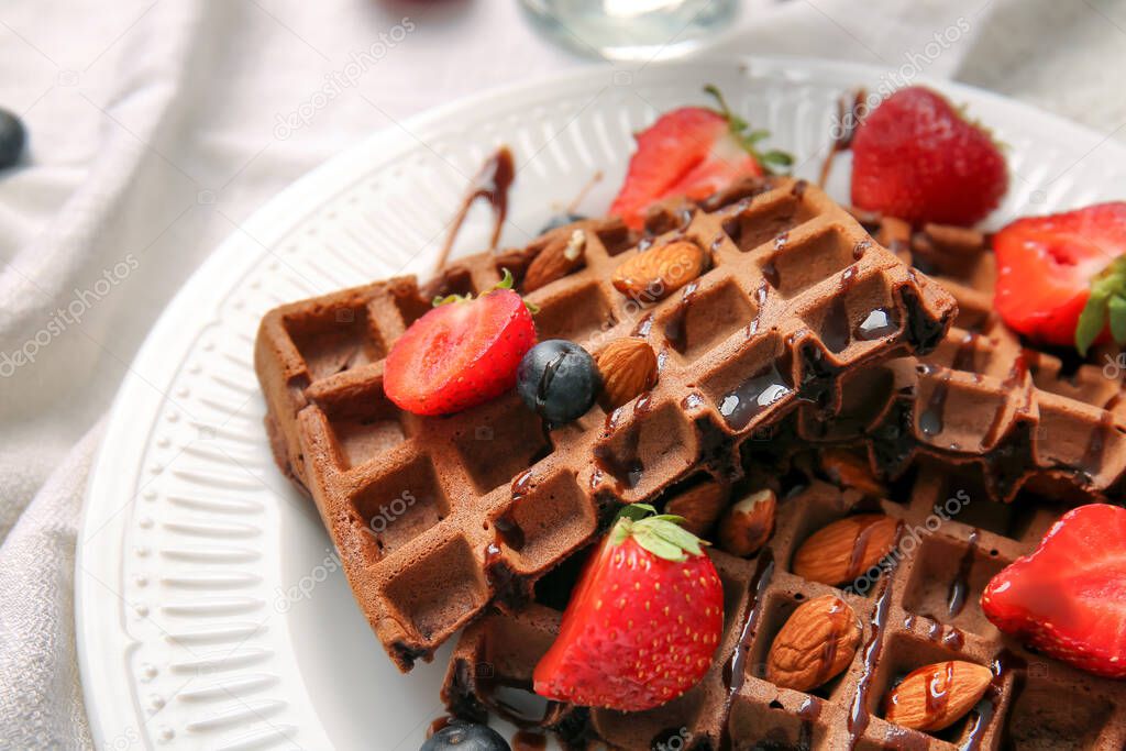 Plate of delicious Chocolate Belgian Waffles with berries and almond on table, closeup