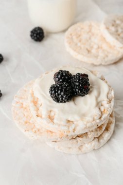 Üzerinde pirinç kraker ve böğürtlen olan parşömen, yakın plan.