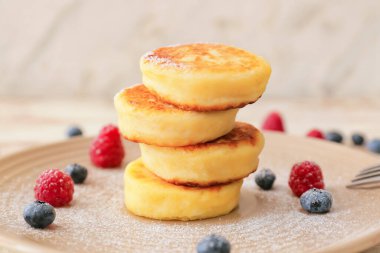 Süzme peynirli krep ve hafif ahşap arka planda böğürtlen tabağı.