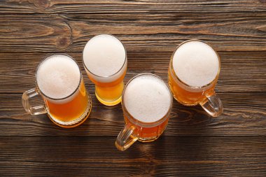 Ahşap arka planda kupalar ve bir bardak soğuk bira. Ekim Festivali Kutlaması