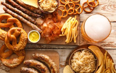 Bir bardak soğuk bira, Bavyera sosisi ve beyaz ahşap arka planda atıştırmalıklar. Ekim Festivali Kutlaması