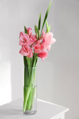 Odada gladiolus çiçekleri olan vazo.