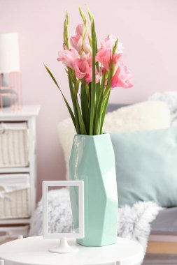 Odada gladiolus çiçekleri olan vazo.