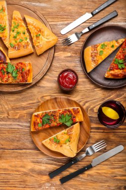 Ahşap zemin üzerinde lezzetli Türk pizzası olan yemek ve tabaklar