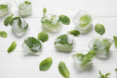 Hafif ahşap zemin üzerinde buz küpleri ve nane yaprakları