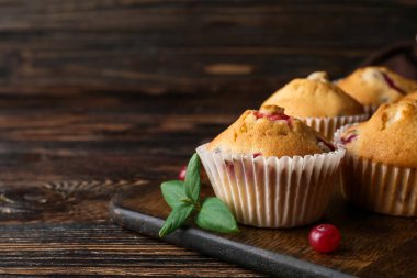 Ahşap arka planda lezzetli yaban mersinli çörekler, yakın plan.