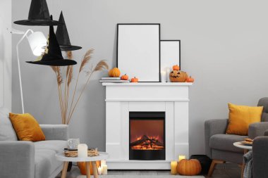 Şömineli ve Cadılar Bayramı dekorasyonlu oturma odasının içi.