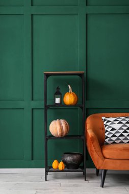Kabaklı raflar ve yeşil duvarın yanındaki kanepe.