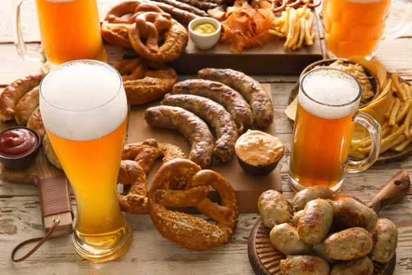 Sklenice Studeného Piva Tabule Bavorskými Klobásami Občerstvení Bílém Dřevěném Pozadí — Stock fotografie