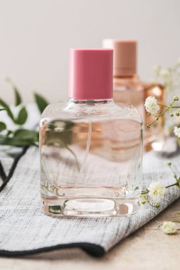 Bir şişe parfüm ve arka planda çingene çiçekleri, yakın plan.