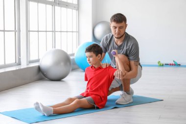 Fizyoterapist rehabilitasyon merkezinde bir çocukla çalışıyor.