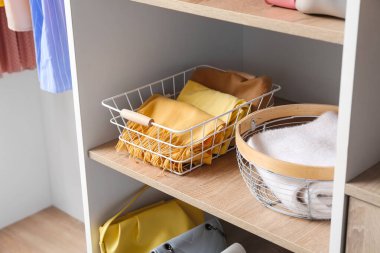 Giysileri gardıropta raflarda olan modern organizatörler.