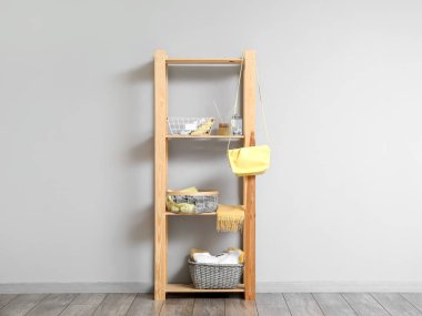 Işık duvarının yanında gardırop düzenleyicileri olan raf ünitesi.