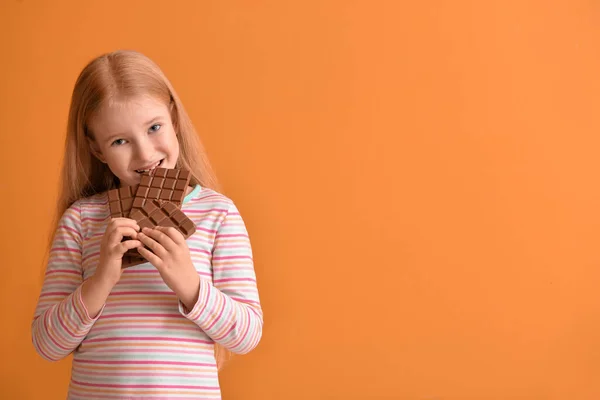 Cute Little Girl Eating Chocolate Color Background — Stock Photo, Image