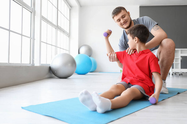 Physiotherapist working with boy in rehabilitation center