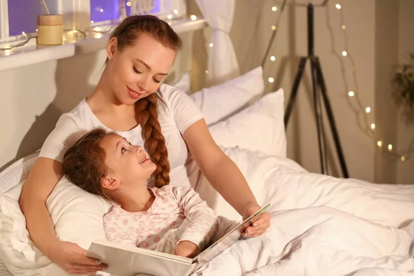 小さな女の子とともに彼女のお母さん読書就寝前の話前に寝る — ストック写真