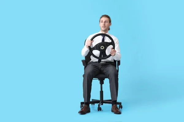 Νεαρός Άνδρας Τιμόνι Κάθεται Στην Καρέκλα Φόντο Χρώμα — Φωτογραφία Αρχείου