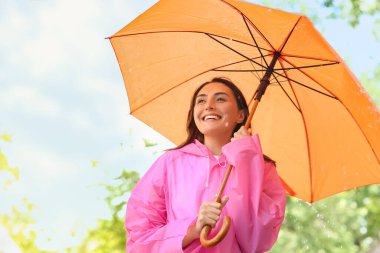 Dışarıda şemsiyesi olan güzel genç bir kadın.