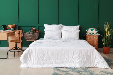 Renkli duvarın yanında rahat yatak ve işyeri olan şık bir oda.