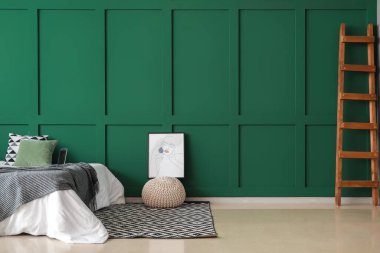 Rahat yatak, şilte ve resim renkli duvarın yanında.