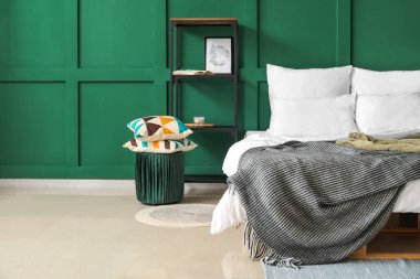 Çift kişilik yatak, yeşil yatak odasının içinde rahat bir battaniye.