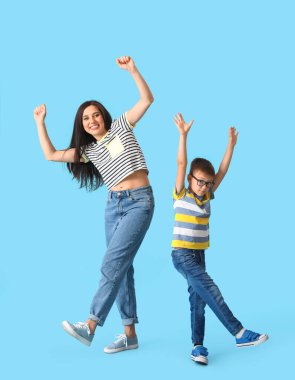 Dans eden genç kadın ve küçük oğlu renkli arka planda