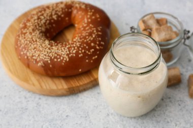 Beyaz arka planda taze ekşi mayalı kavanoz aç