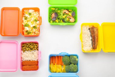 Lezzetli yiyeceklerle dolu pek çok plastik kap beyaz, yakın plan