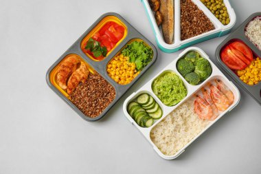 Hafif arka planda farklı sağlıklı yiyeceklere sahip konteynırlar