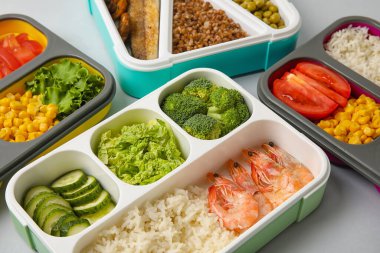 Gri masada farklı sağlıklı yiyecekleri olan kaplar, yakın plan.