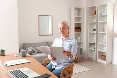 Ofiste çalışan olgun bir kadın.